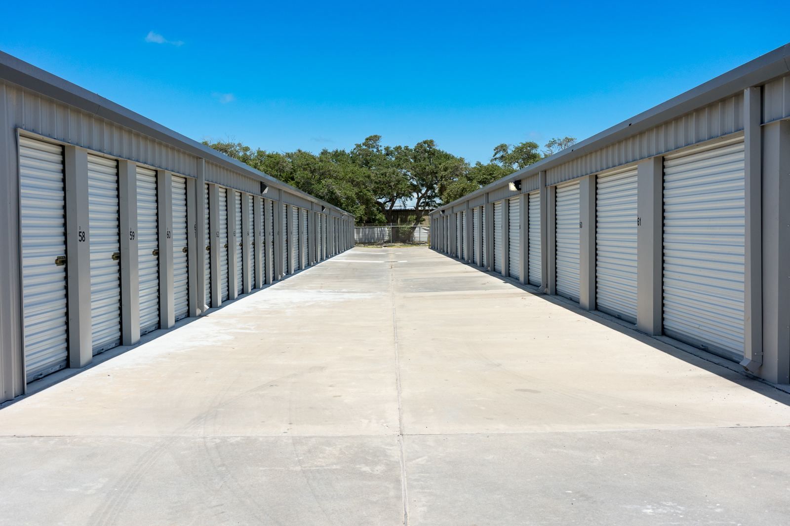 Wide concrete drive between drive-up storage buildings at Siyata Storage in Rockport, Texas