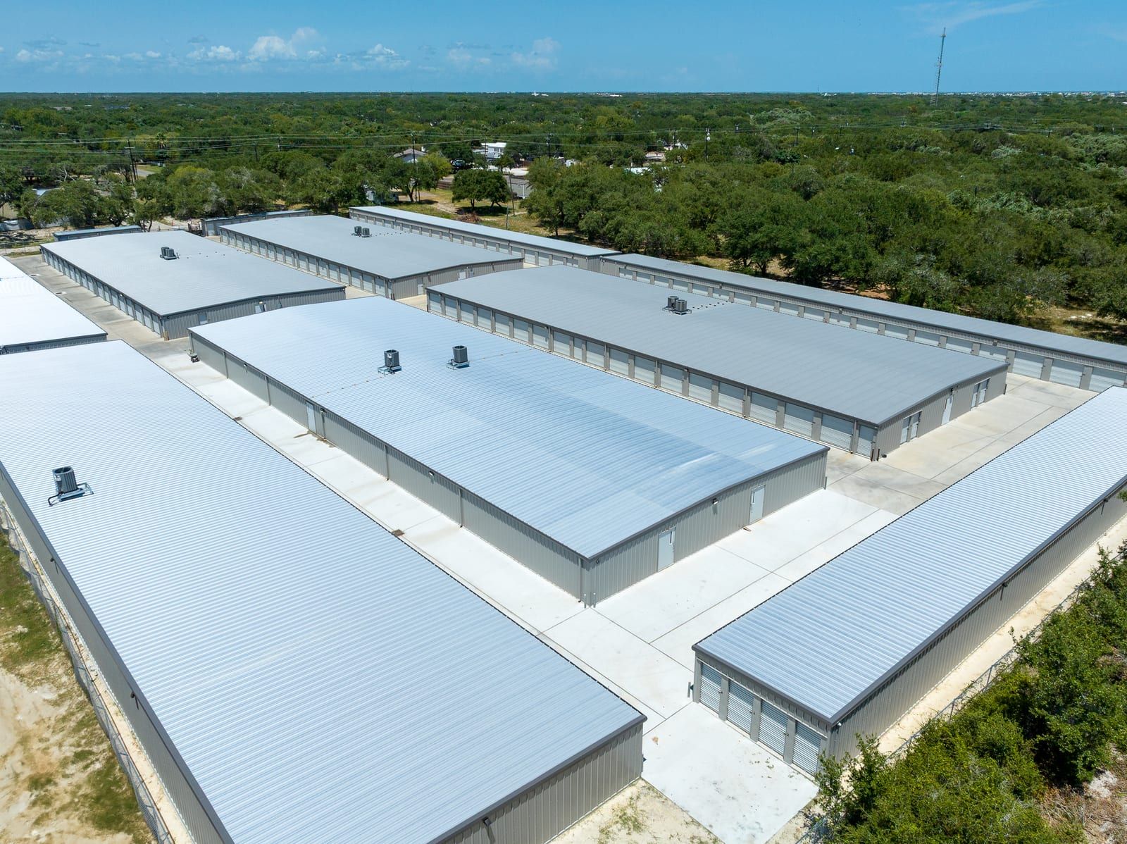 Aerial view of metal storage buildings with roll-up doors, rooftop HVAC units and wide concrete drive aisles